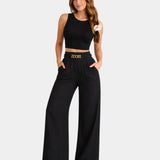 Black high-waist wide-leg pants with gold chain belt detail