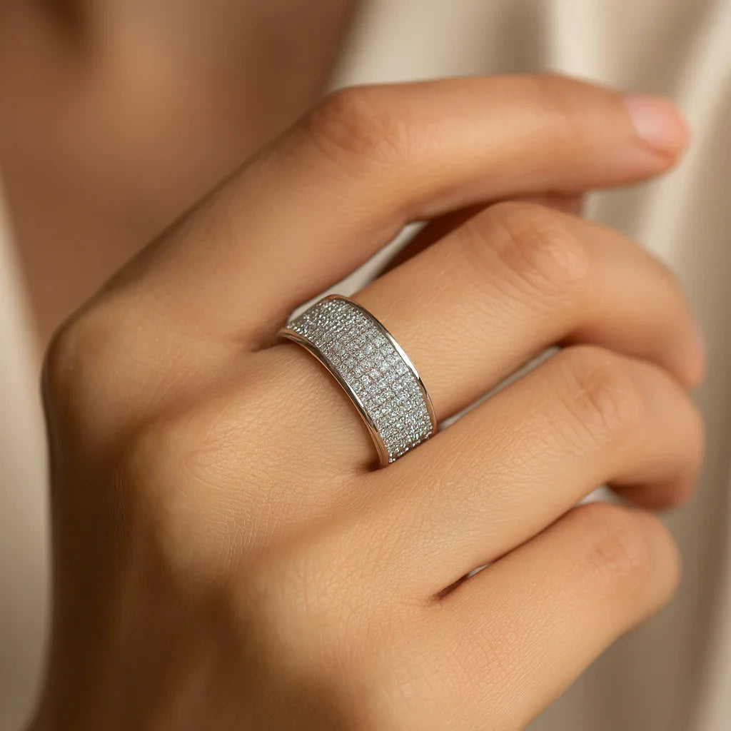 Silver-tone shiny ring with a wide textured band on finger