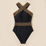 Black one-piece swimsuit with gold lattice halter straps and fitted waist band