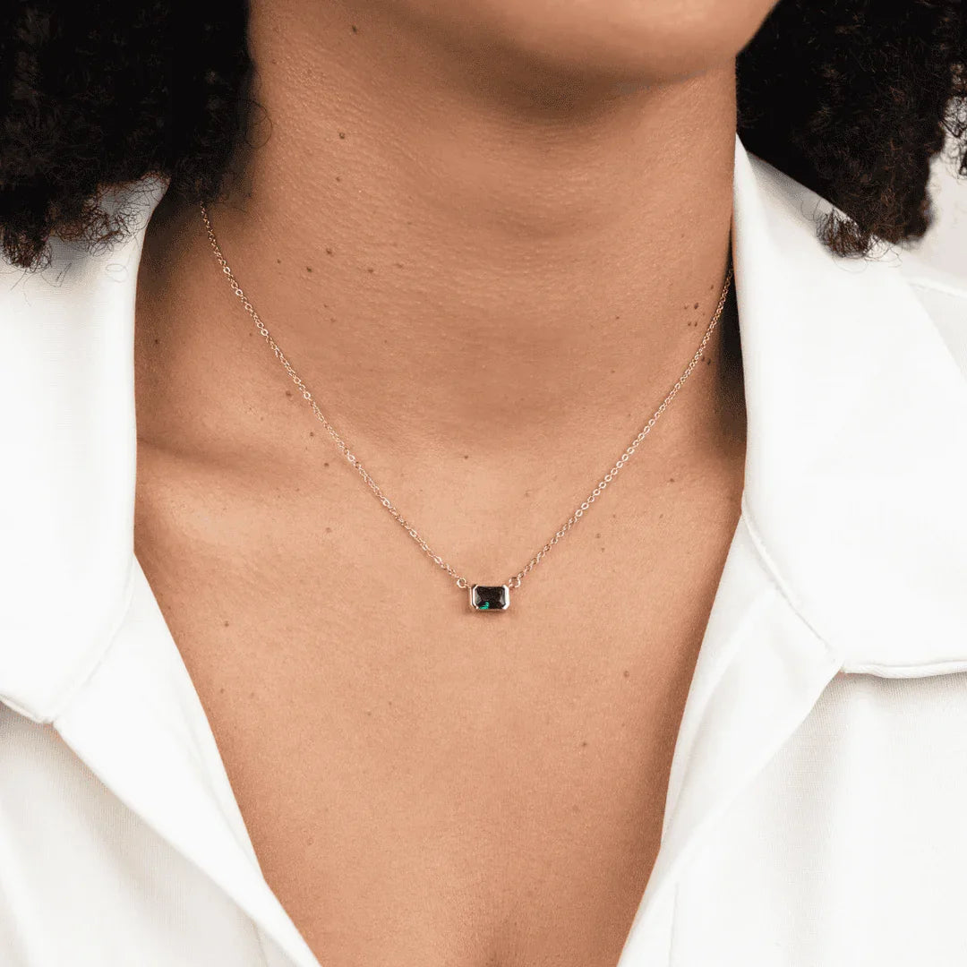 Green square emerald pendant on a delicate chain, worn at the collar