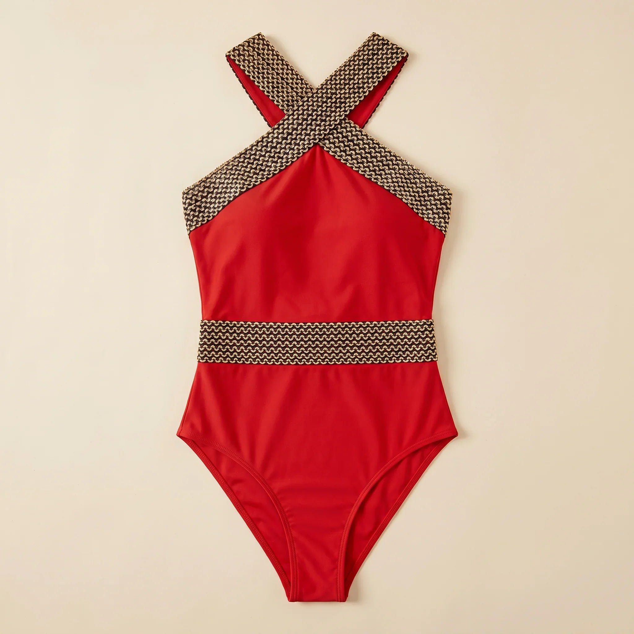 Red one-piece swimsuit with gold lattice halter straps and crisscross back