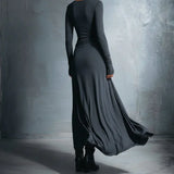 Dark long-sleeve maxi dress, back view, fitted bodice with draped flowing skirt