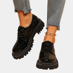 Black patent leather derby shoes with lace-up front and chunky lug sole