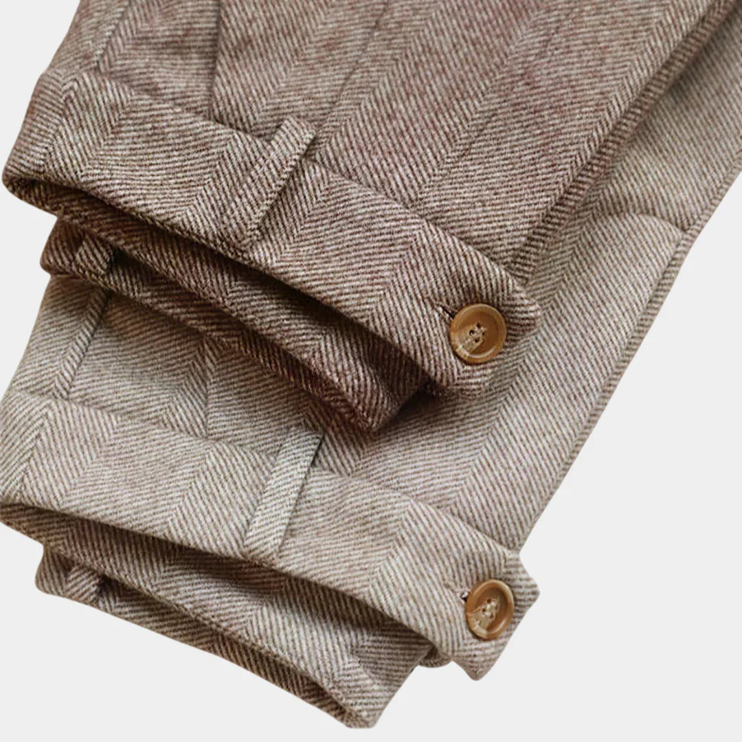 Tan herringbone trousers with buttoned front and pleated waistband