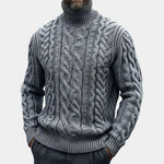 Gray cable knit turtleneck sweater with twisted braided texture, ribbed cuffs and hem.