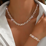 Rose-gold fish-tail link necklace with matching bracelet at neckline