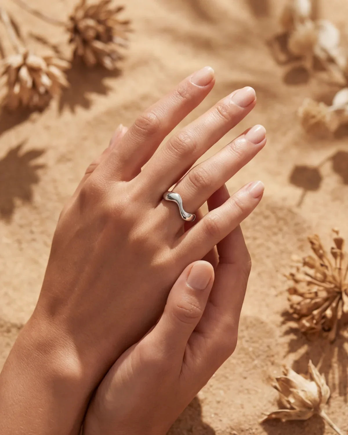Silver wavy open-band ring close-up on fingers