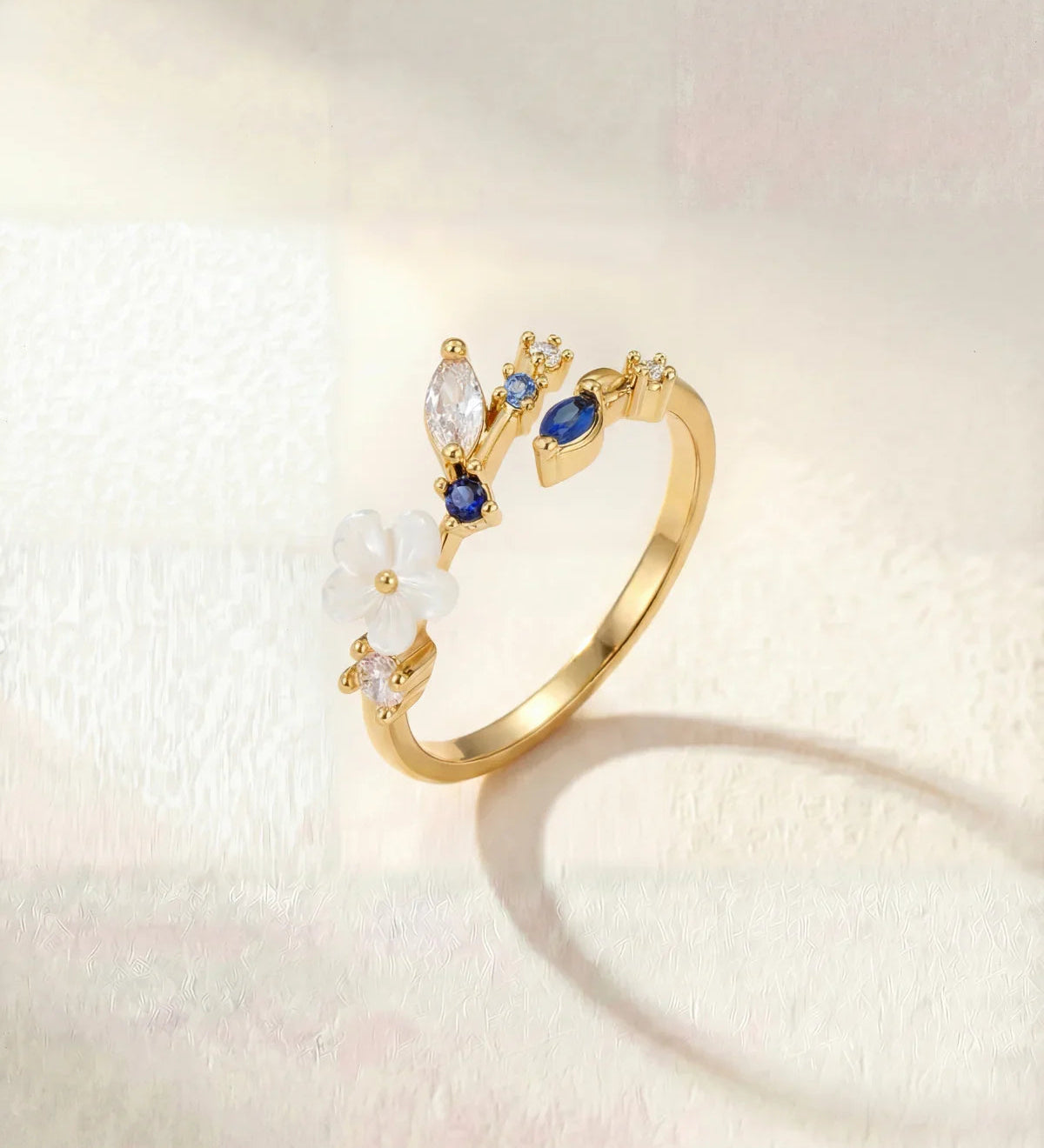 Gold-tone elegant ring with blue and clear stone flower cluster