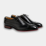 Black lace-up brogue dress shoes with perforated detailing and cap toe