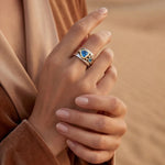 Silver ring with blue oval stone, gold-toned bezel, and swirl-style detail