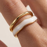 Adjustable gold ring with white inlay stripe, side view on hand