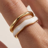 Adjustable gold ring with white inlay stripe, side view on hand