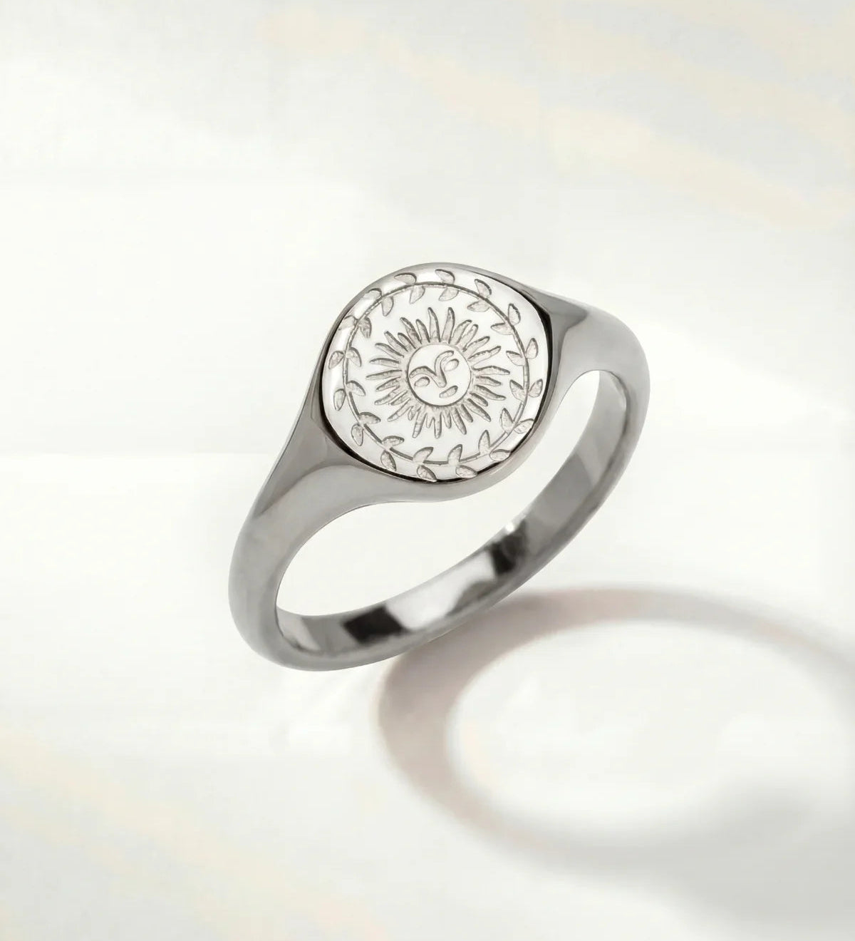 Silver-tone ring with oval sunburst engraving on the top and a smooth band