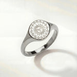 Silver-tone ring with oval sunburst engraving on the top and a smooth band
