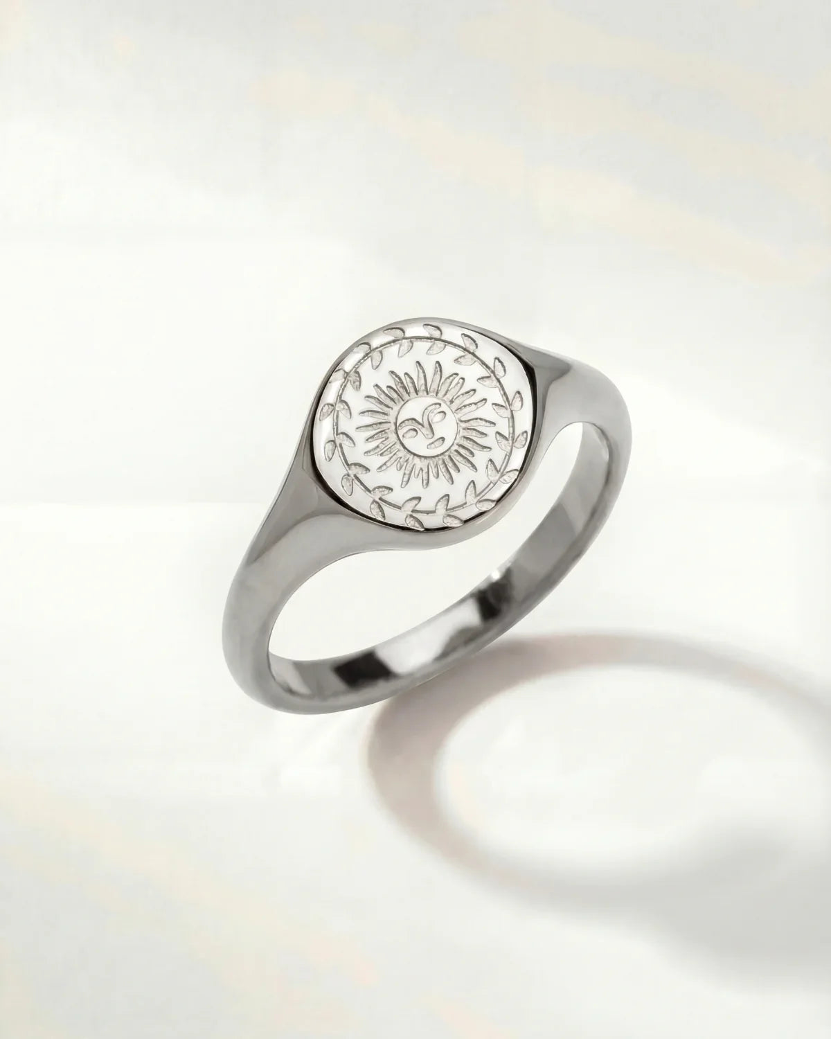 Silver-tone ring with oval sunburst engraving on the top and a smooth band