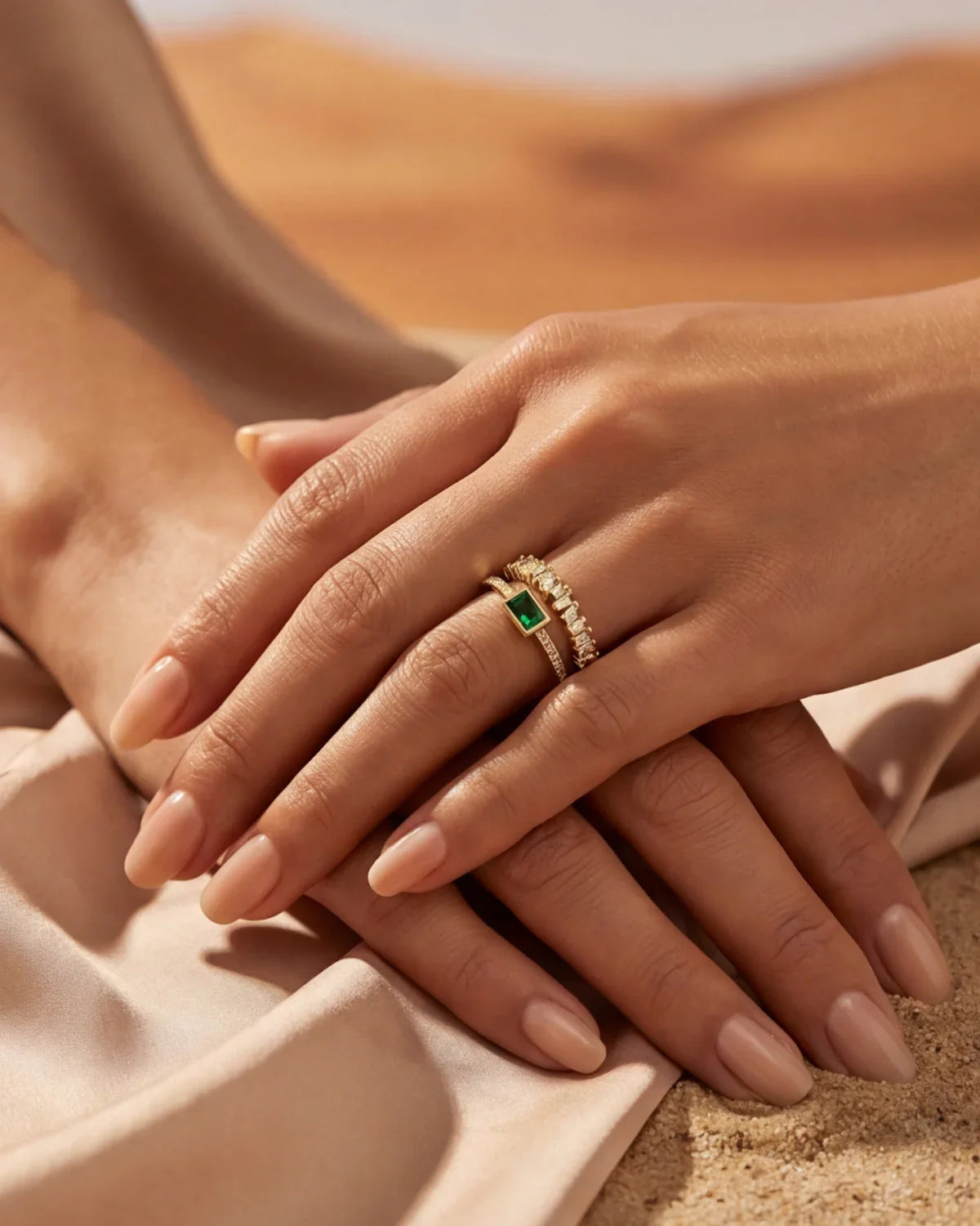 Gold adjustable statement ring with green square stone and clear halo on hand