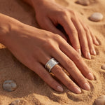 Silver ring with a large rectangular white stone on a hand