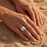 Silver ring with a large rectangular white stone on a hand