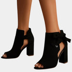 Black heeled sandals with peep toe, ankle bow, and block heel