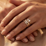 Gold ring set with stacked bands and clear stones on a hand