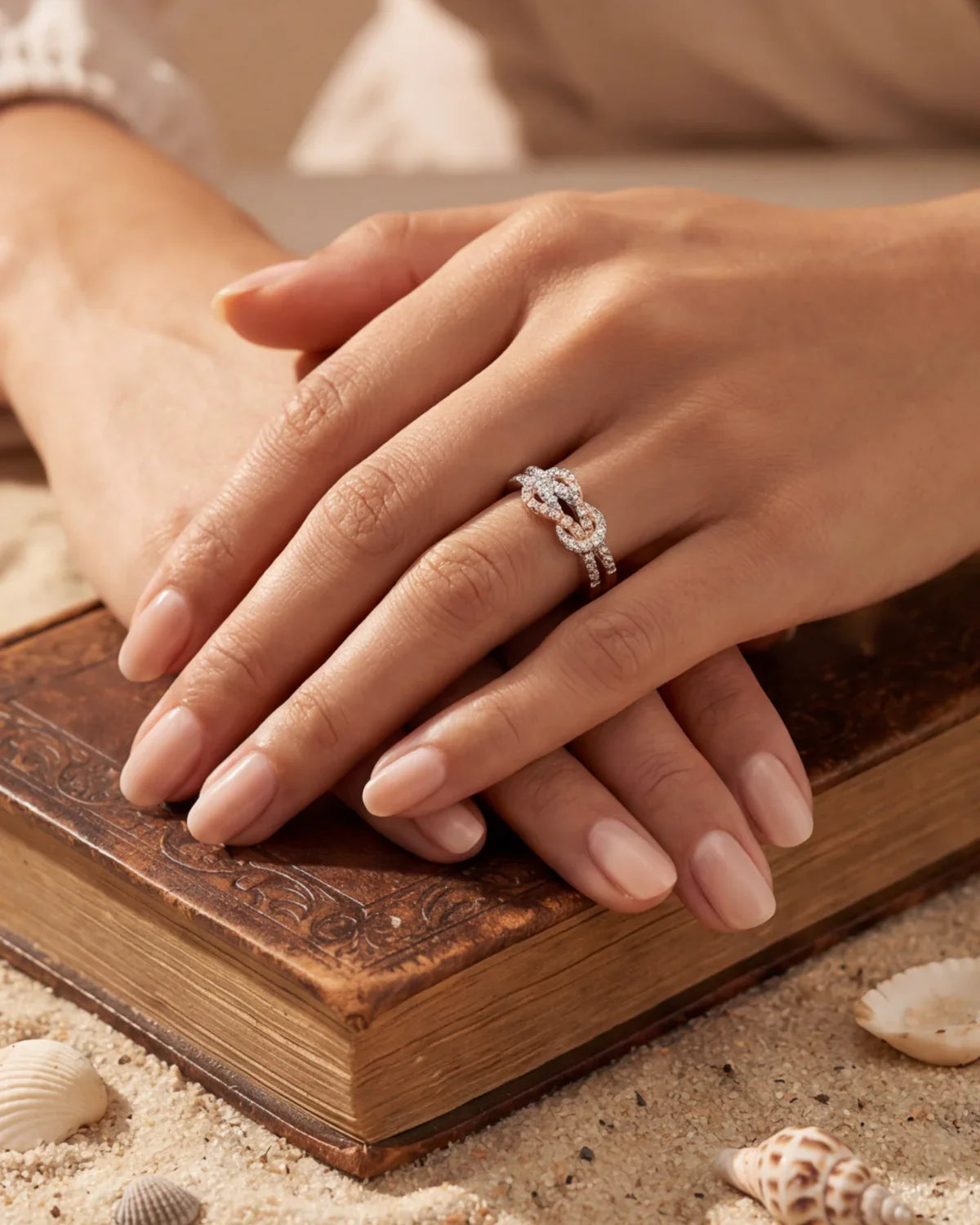 Rose gold infinity ring with clustered sparkling stones, close-up on hand