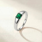 Silver-tone ring with a square green gemstone set on a tapered band