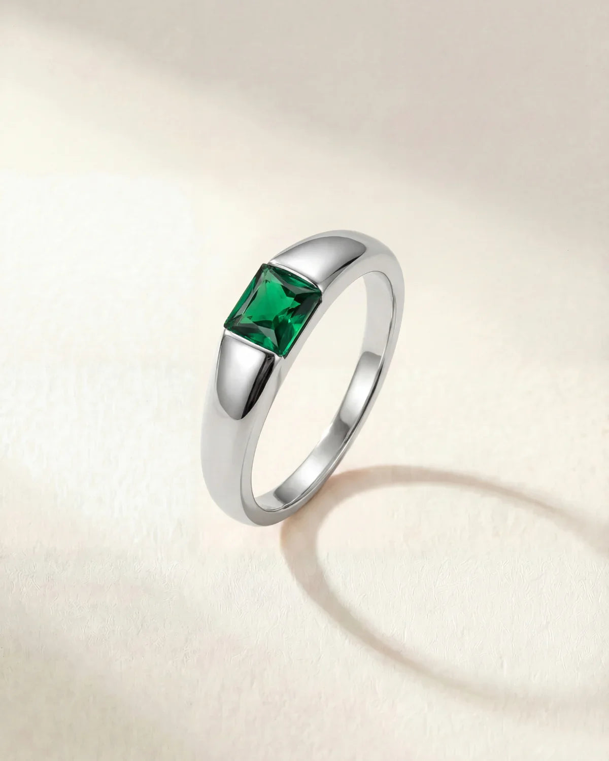 Silver-tone ring with a square green gemstone set on a tapered band
