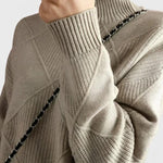 Gray turtleneck sweater with ribbed collar, diamond knit panels, and long sleeves