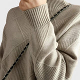 Gray turtleneck sweater with ribbed collar, diamond knit panels, and long sleeves