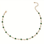 Gold-tone emerald station necklace featuring dark green oval stones in a row