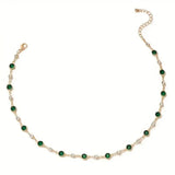 Gold-tone emerald station necklace featuring dark green oval stones in a row