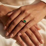 Close-up of a green square gemstone ring on a gold-tone band