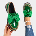 Green heeled loafers with chunky sole and large green bow accent