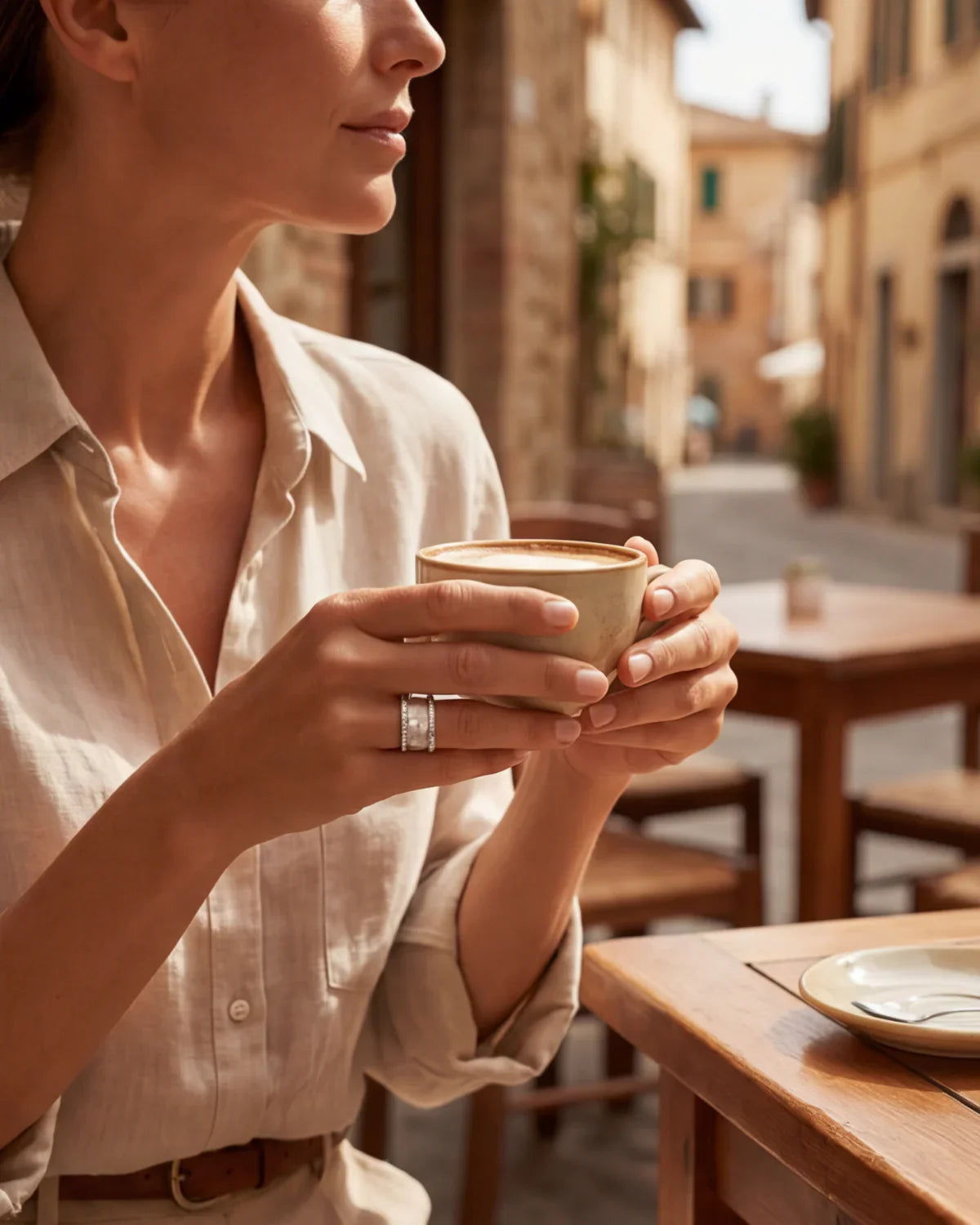 Silver elegant ring on a hand holding a coffee cup