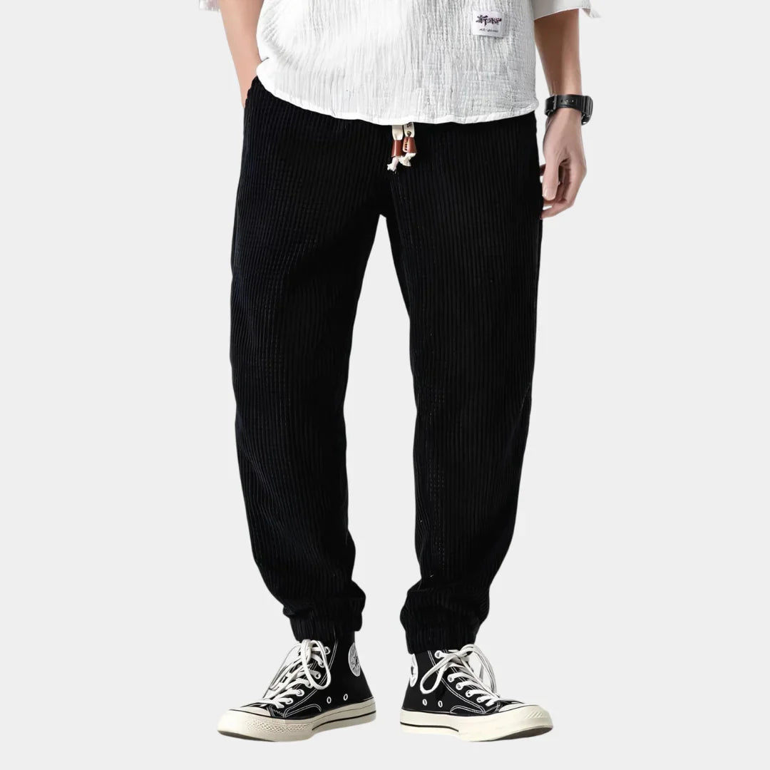 Black corduroy pants with ribbed texture and drawcord hem