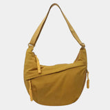 Yellow anti-theft crossbody bag with curved hobo shape, adjustable strap, and zipper detail.