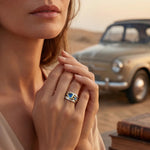 Silver ring on finger with blue center stone and gold-toned accents