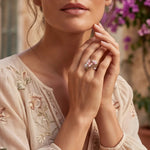 Bronze floral ring with pink petals and small sparkling stones on finger