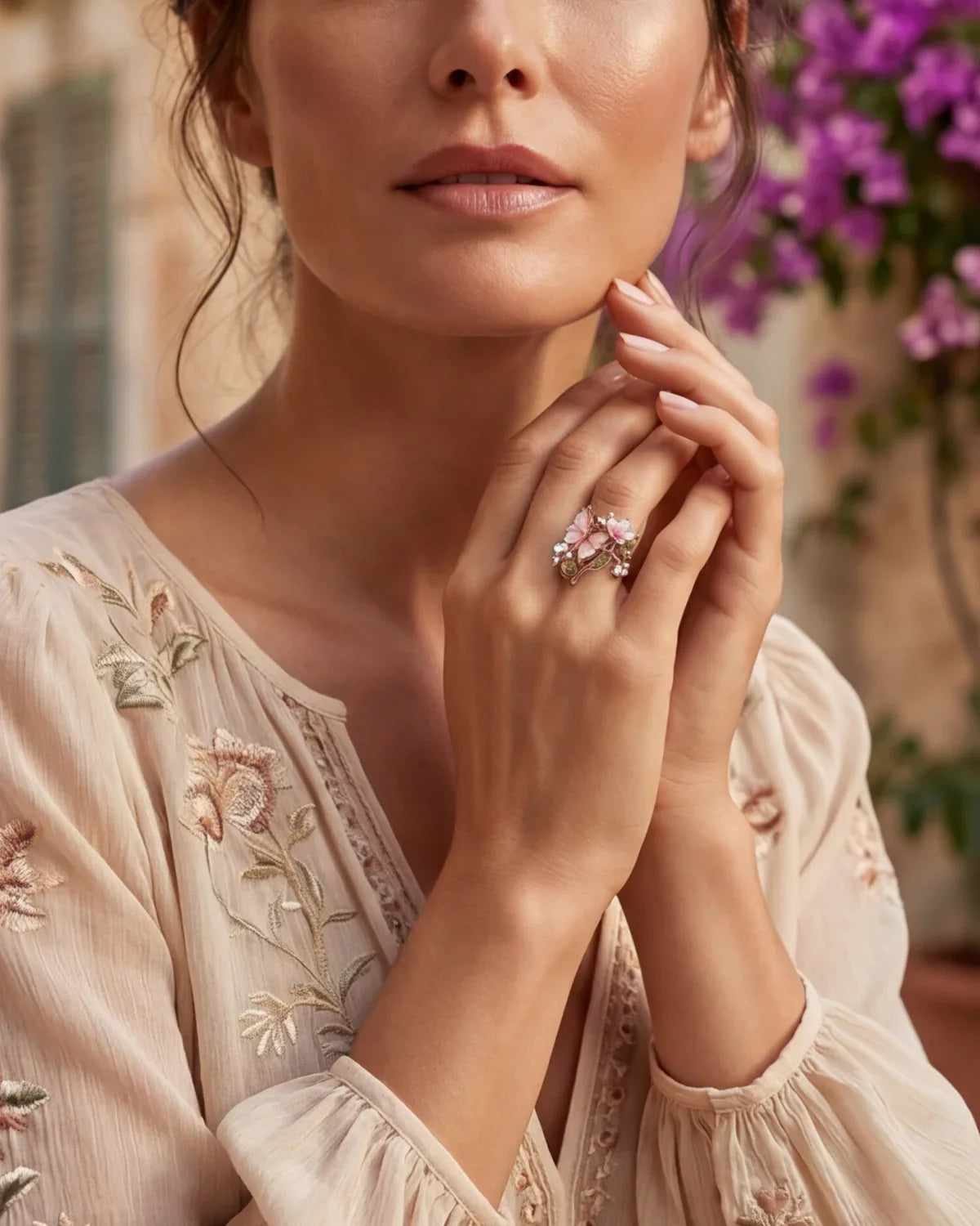 Bronze floral ring with pink petals and small sparkling stones on finger