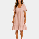Light pink textured V-neck midi dress with short sleeves and tiered skirt