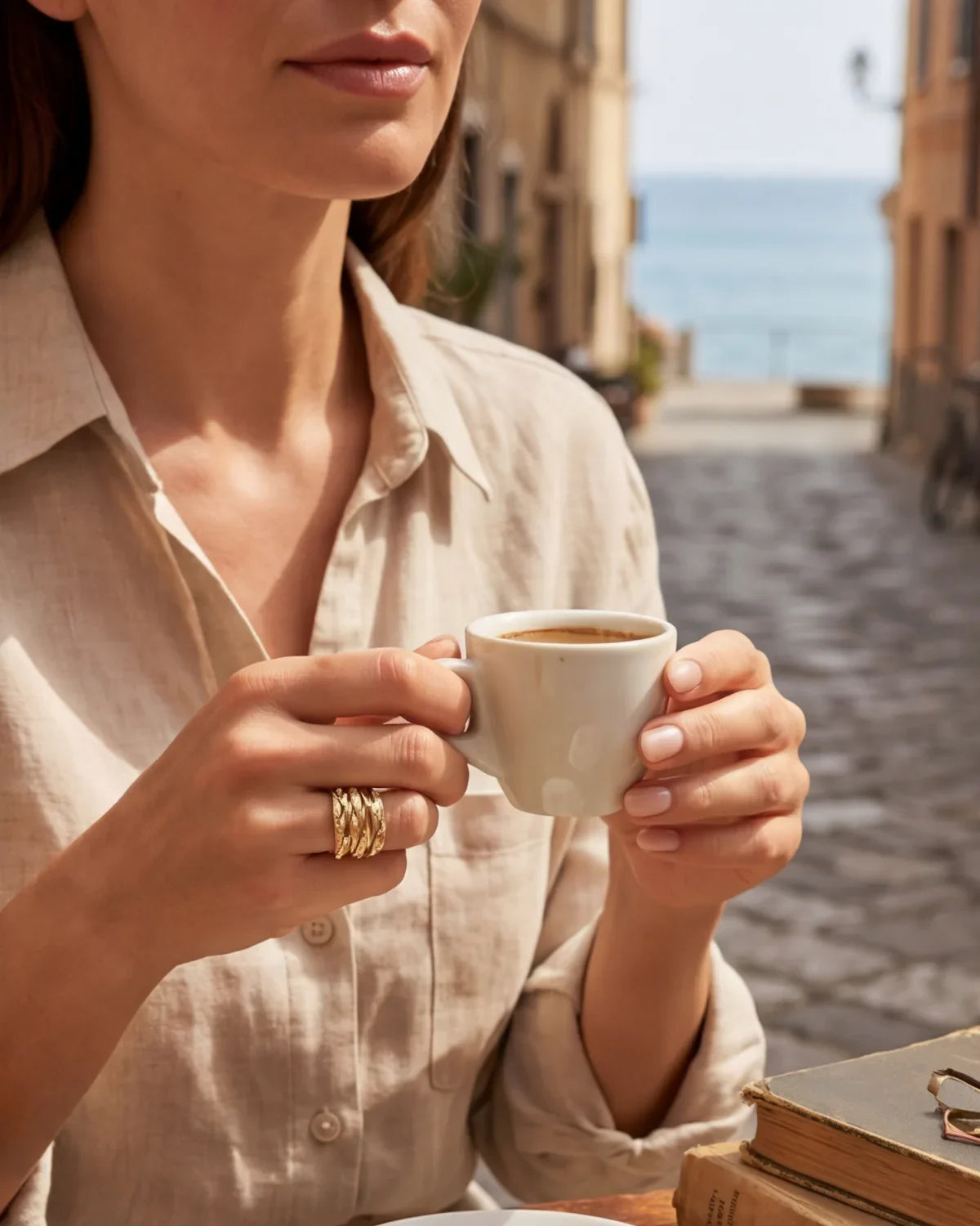 Gold-tone ring with textured curved band and small clear gemstone accents