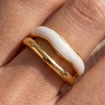 Close-up: adjustable gold ring with white inlay stripe and polished finish