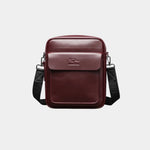 Wine red leather shoulder bag with flap, top handle, and adjustable crossbody strap