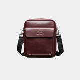 Wine red leather shoulder bag with flap, top handle, and adjustable crossbody strap