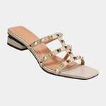 Cream studded slide sandals with crisscross straps and gold square studs