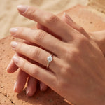 Solitaire ring with round gemstone on finger, close-up