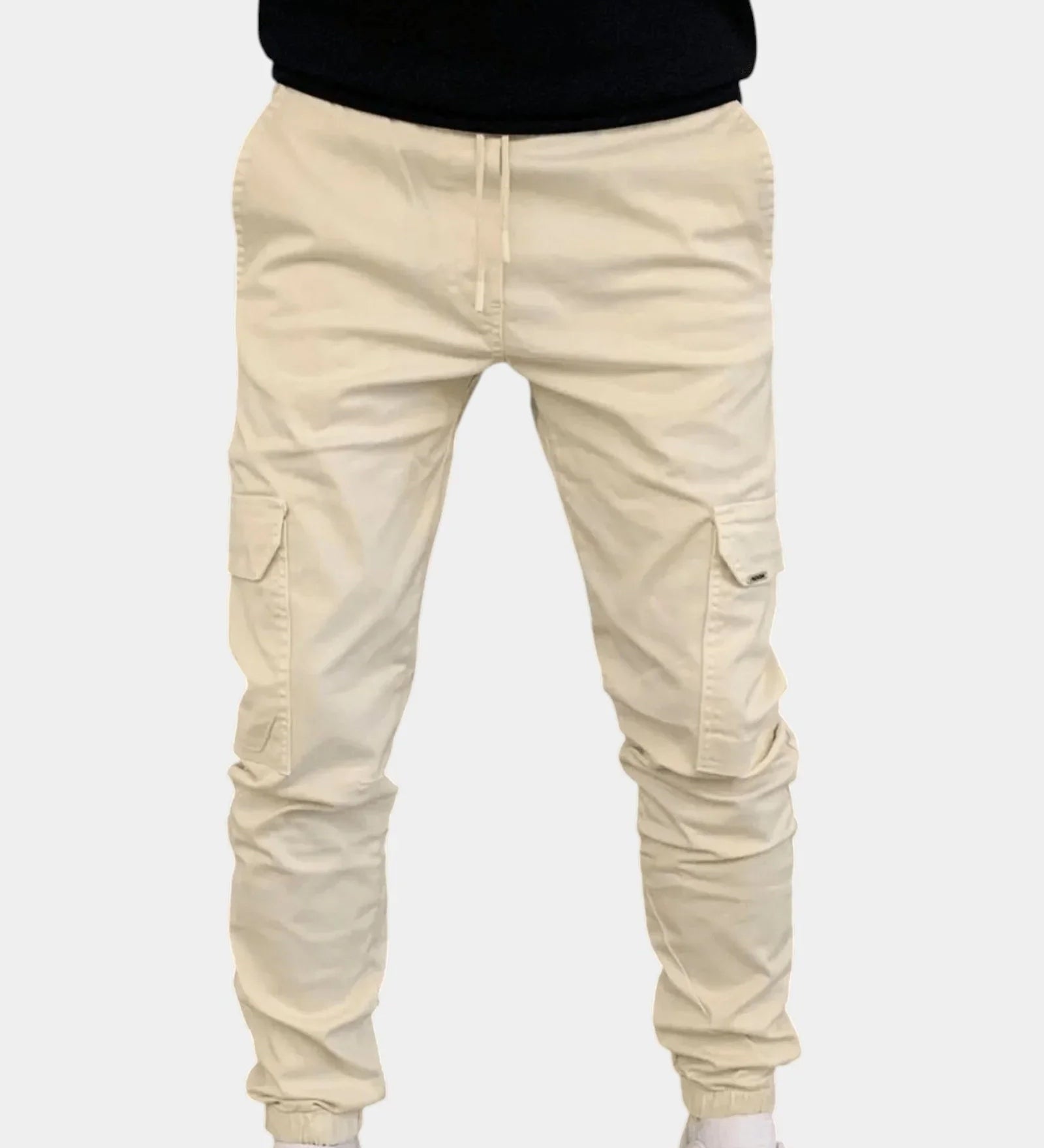 Beige cargo jogger pants with drawstring waist, side cargo pockets, elastic cuffs.