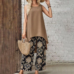 Taupe sleeveless tunic layered over black wide-leg pants with gold paisley motifs