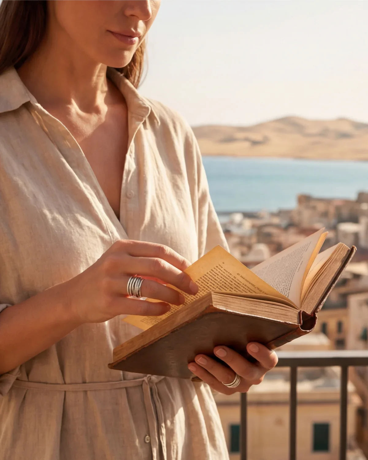 Silver ridged modern ring on hand holding an open book