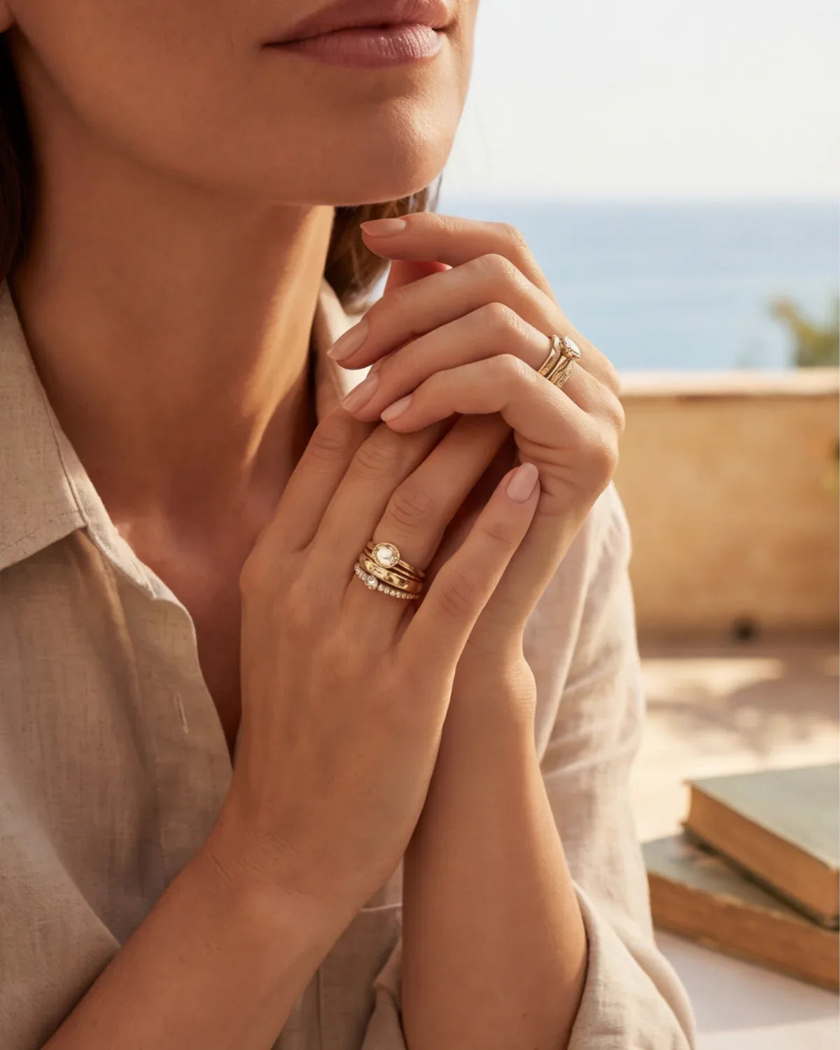 Gold ring set worn on a hand, featuring stacked bands and a small stone ring